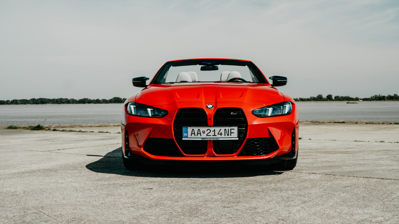 Вид спереди на красный автомобиль BMW M4 Competition M xDrive Cabrio 2024 года