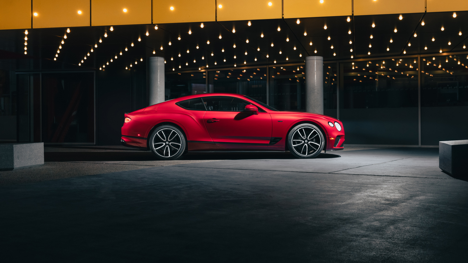 Вид сбоку на красный автомобиль Bentley Continental GT V8 Edition 2024 года