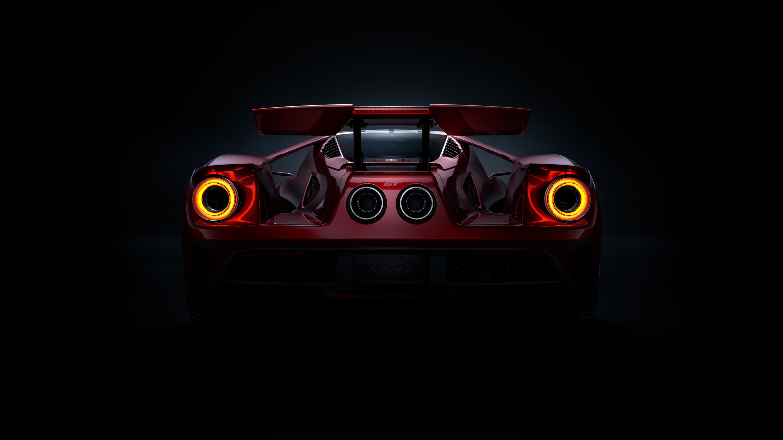 Вид сзади на автомобиль Ford GT  на черном фоне