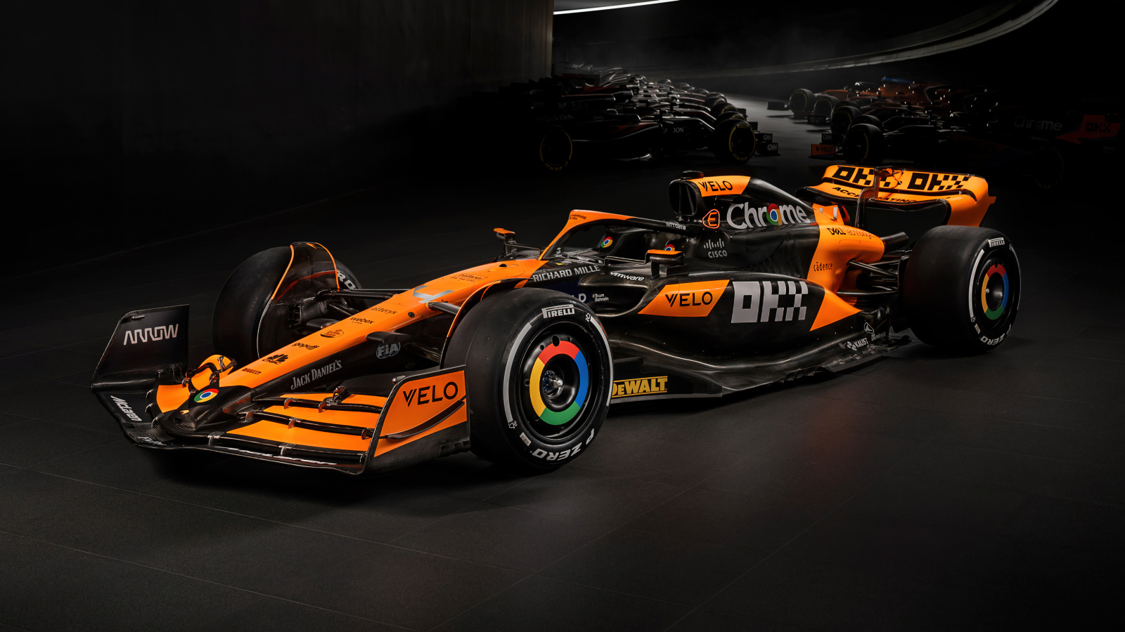 Гоночный автомобиль McLaren MCL38 Formula 1 2024 года на черном фоне