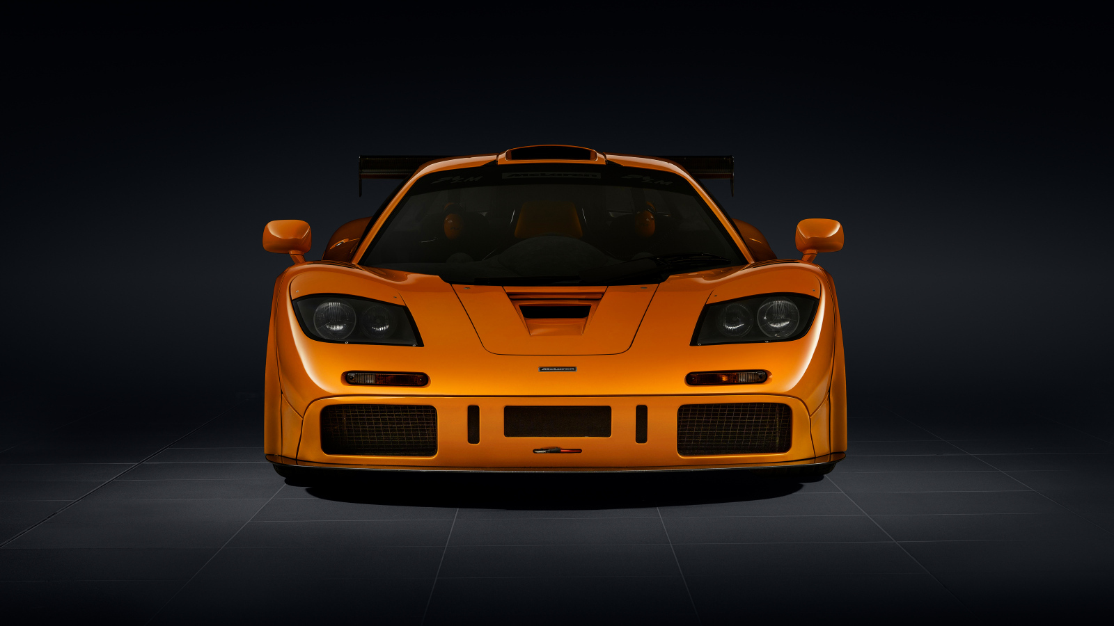 Вид спереди на оранжевый автомобиль McLaren F1 LM