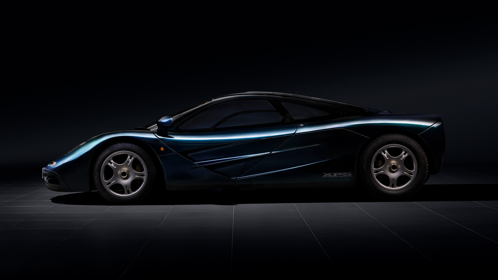 Вид сбоку на черный дорогой автомобиль McLaren F1