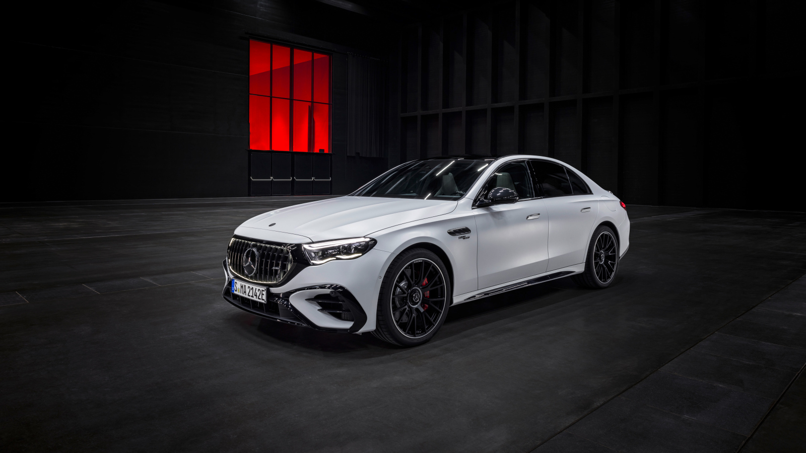 Белый автомобиль Mercedes-AMG E 53 HYBRID 4MATIC+ 2024 года на черном фоне