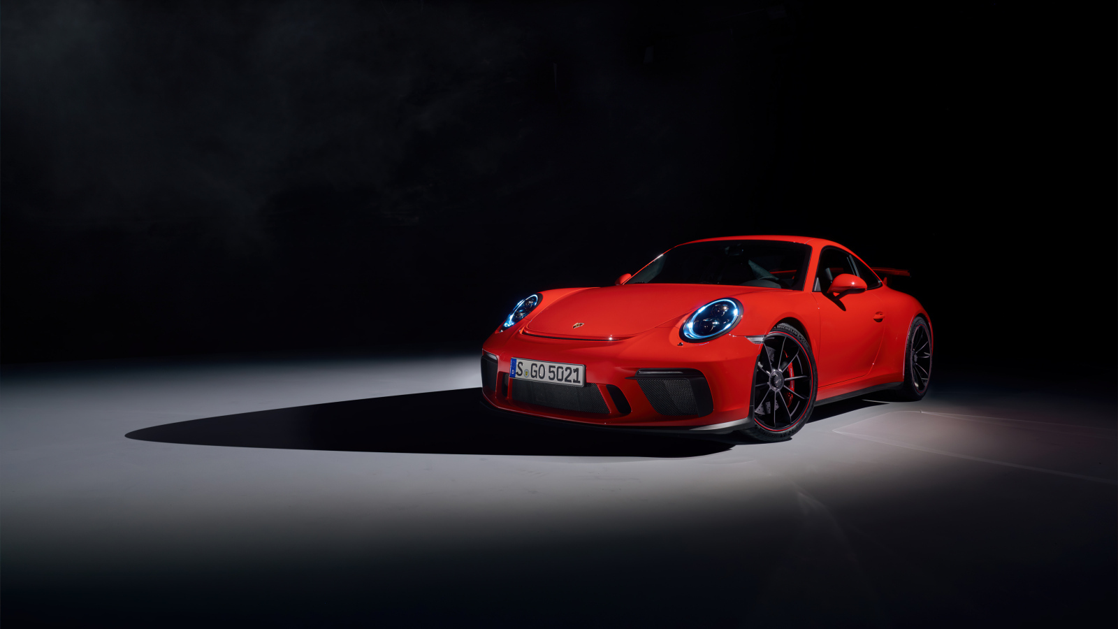 Красный автомобиль Porsche 911 GT3 на черном фоне