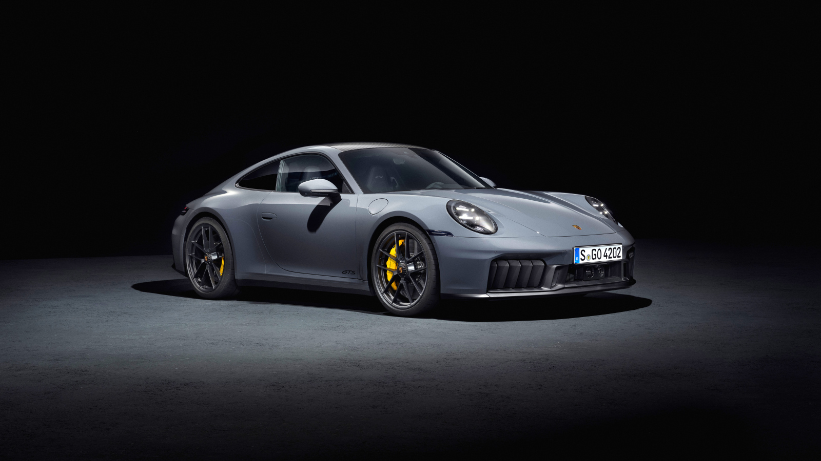 Серебристый автомобиль  Porsche 911 Carrera GTS 2024 года