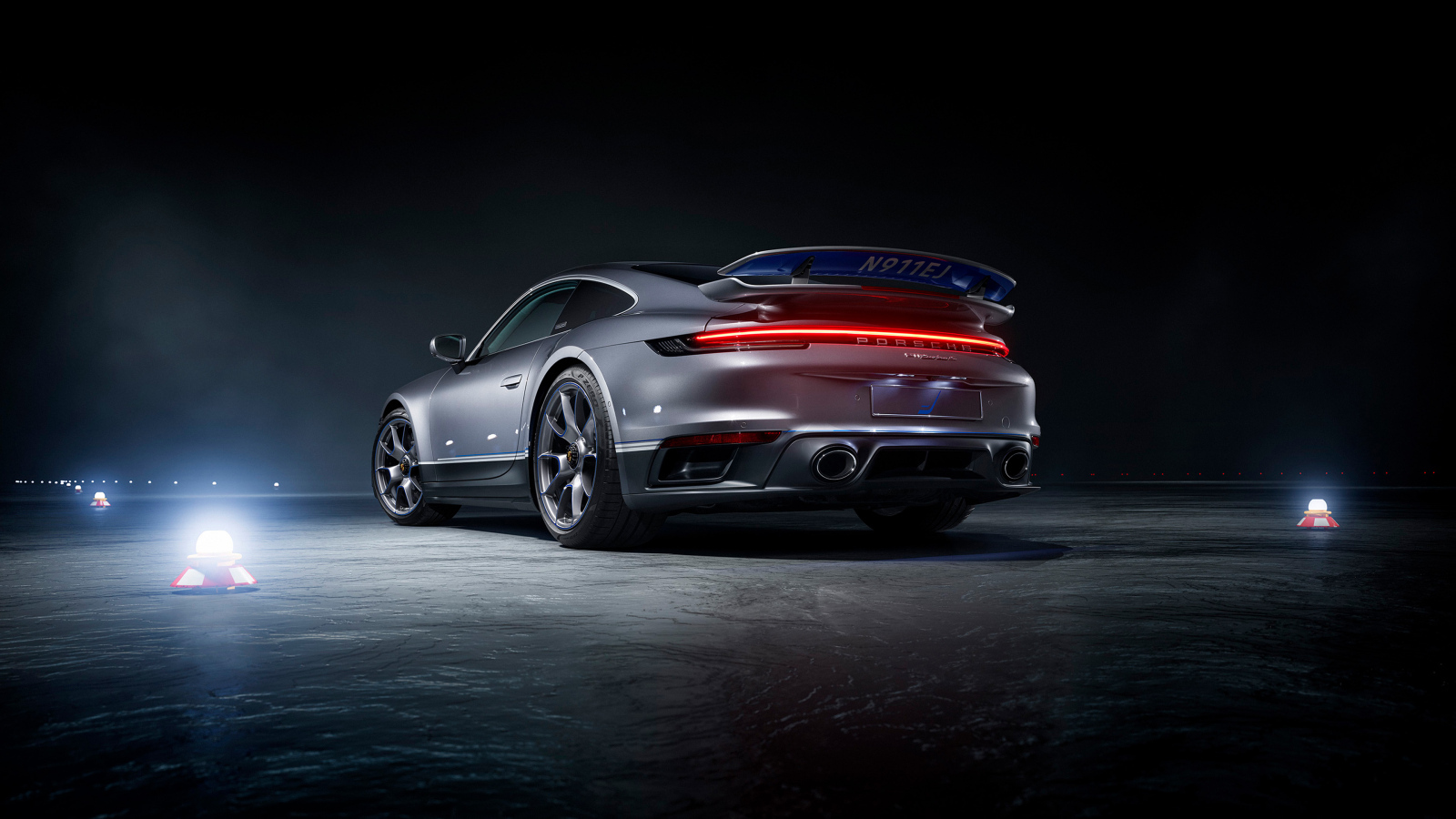 Серебристый автомобиль Porsche 911 Turbo S вид сзади