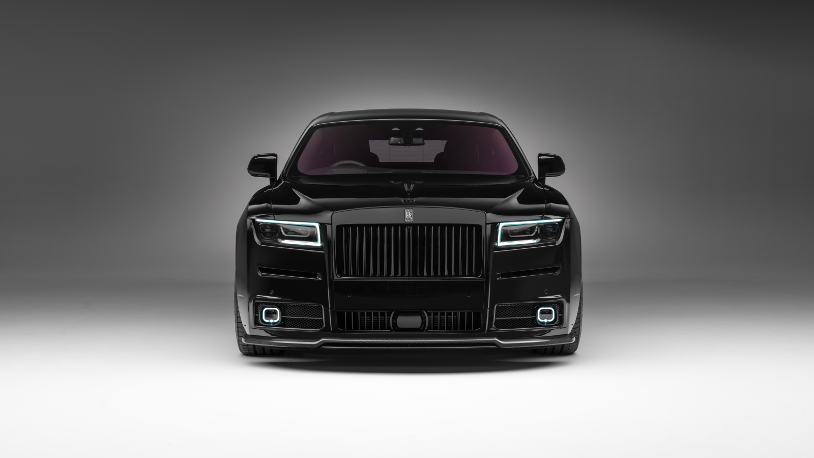 Вид спереди на черный дорогой автомобиль Rolls-Royce Ghost