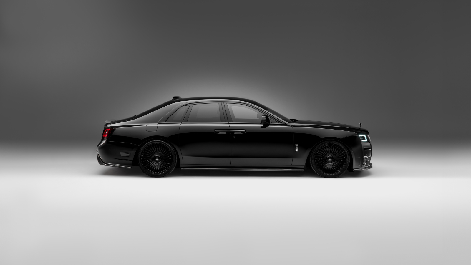 Вид сбоку на черный автомобиль Rolls-Royce Ghost