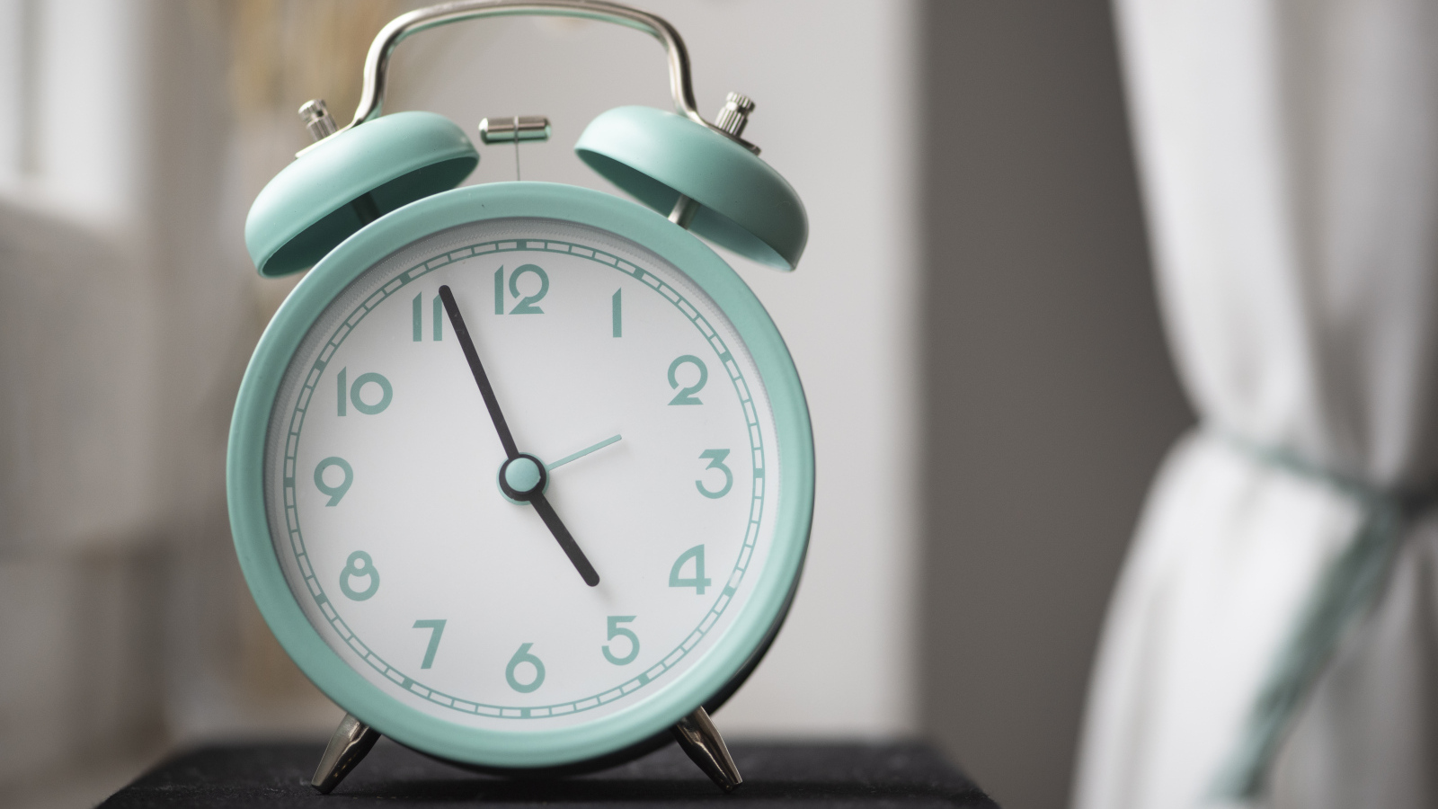 Голубой будильник стоит на книге в комнате