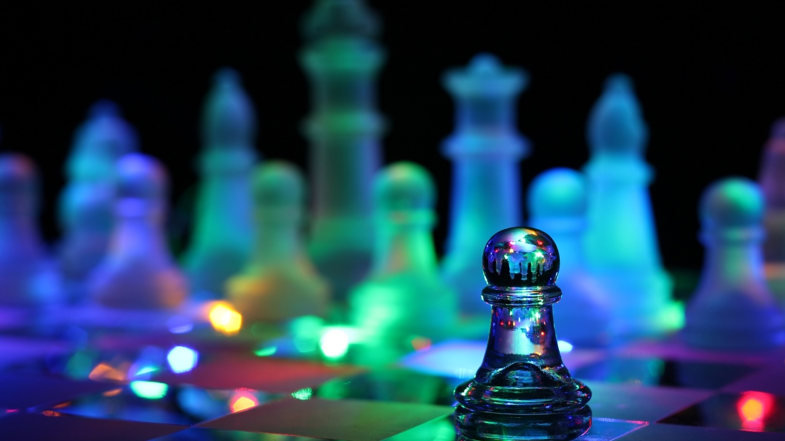 Стеклянные шахматы с гирляндой лежат на доске