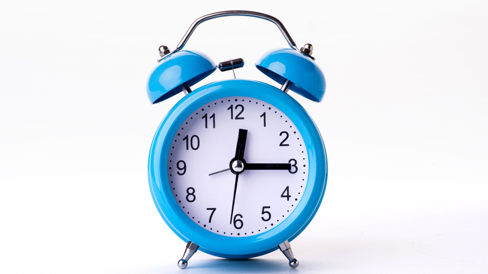 Большой голубой будильник на белом фоне