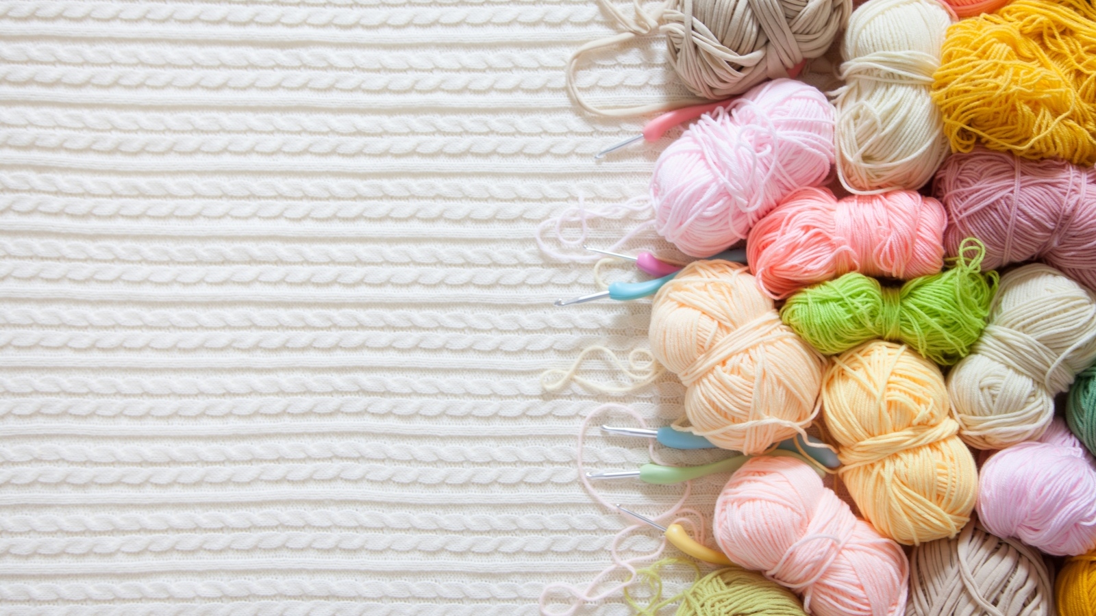 Разноцветная пряжа для вязания на белом трикотажном полотне