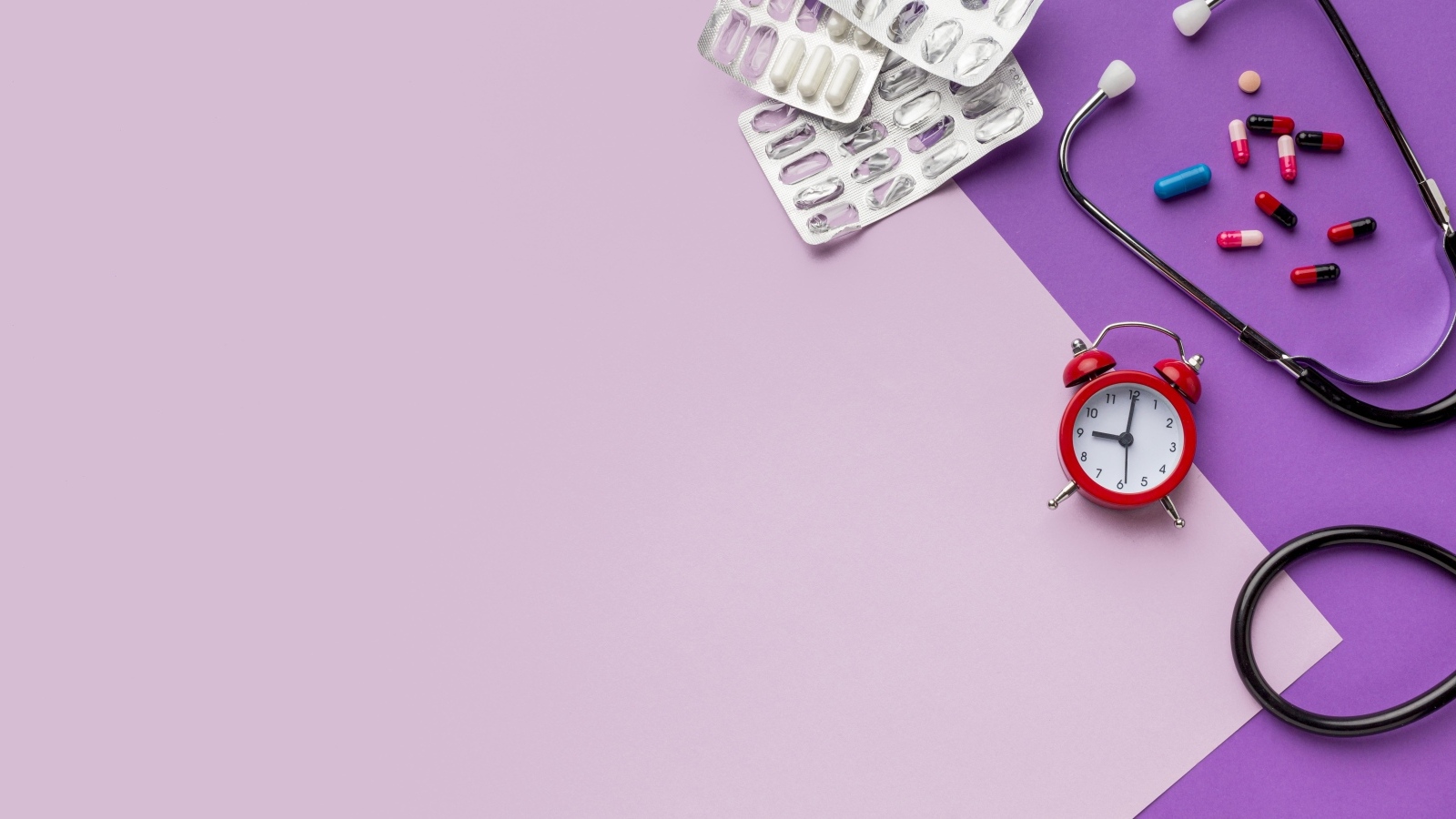 Таблетки, стетоскоп и будильник на сиреневом фоне