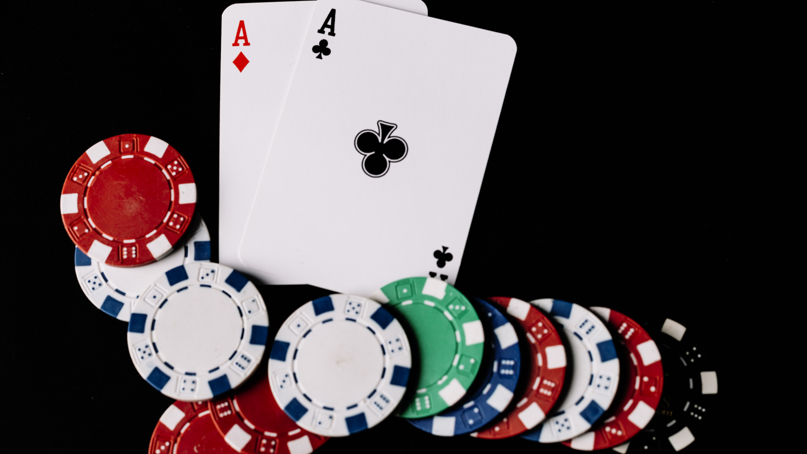 Два туза и фишки для покера  на черном фоне