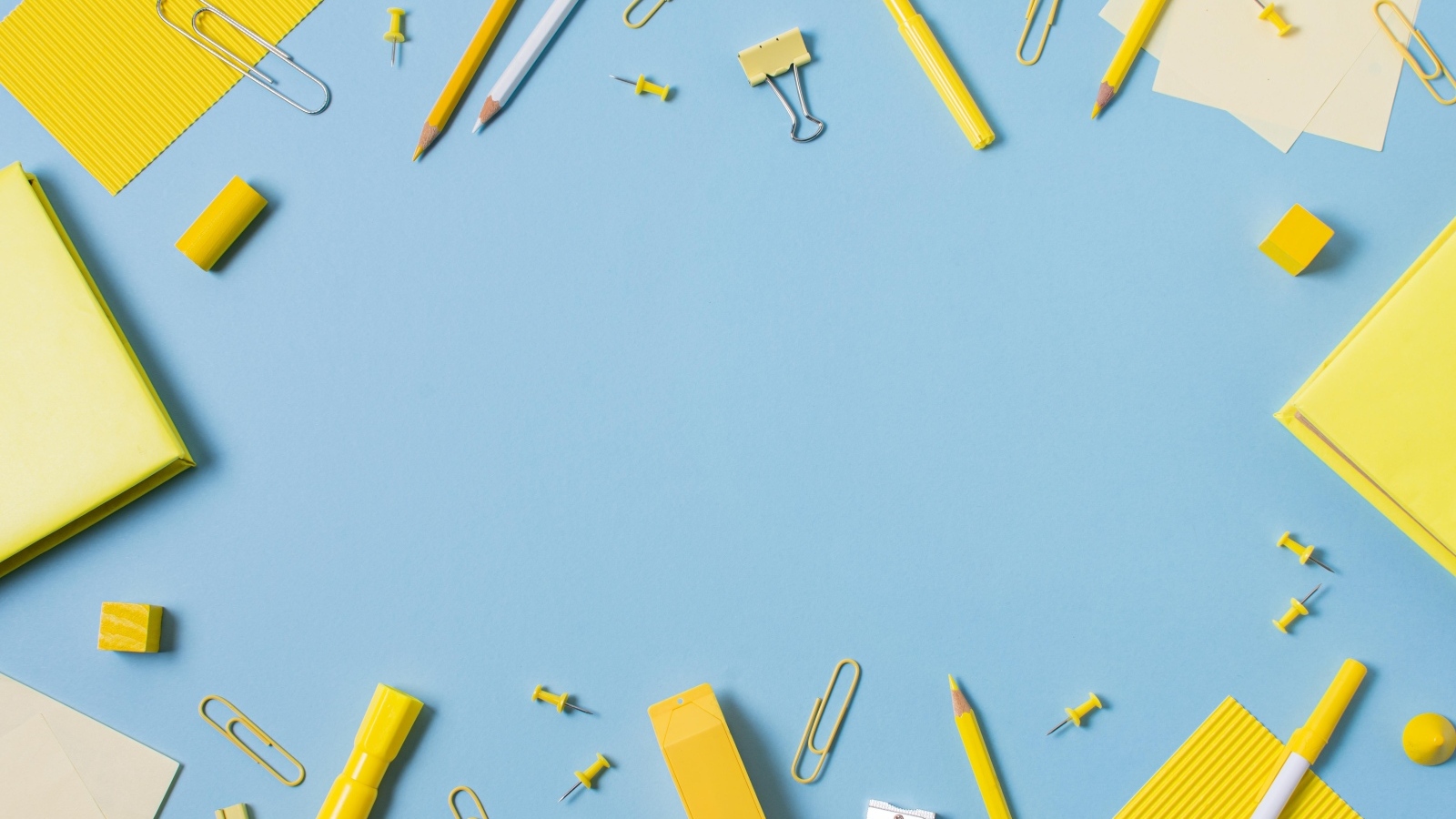 Желтые канцелярские предметы на голубом столе