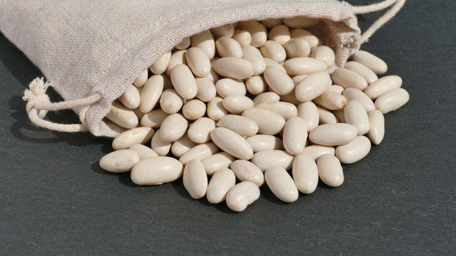 Фасоль в мешочке на сером столе