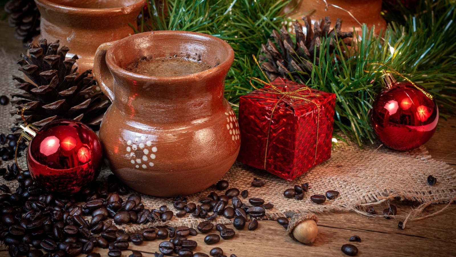 Кофейные зерна на столе с посудой и еловой веткой