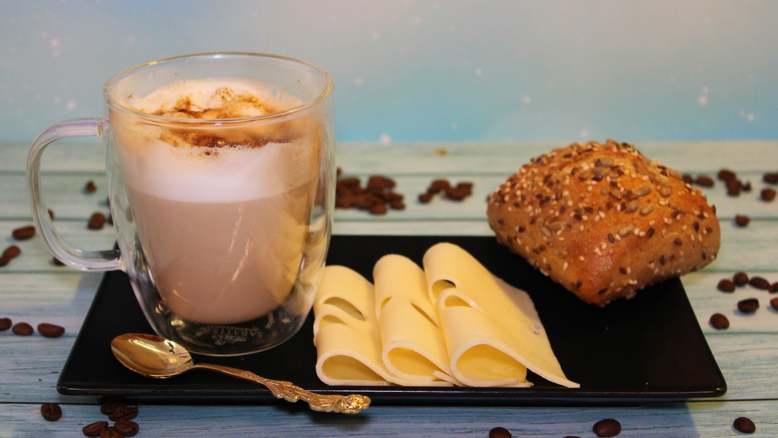 Кофе на тарелке с булочкой и кусочками сыра