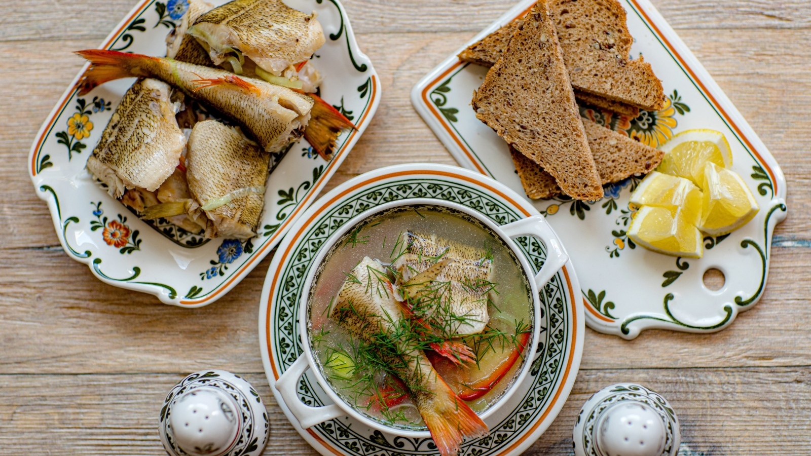Уха на столе с хлебом и лимоном