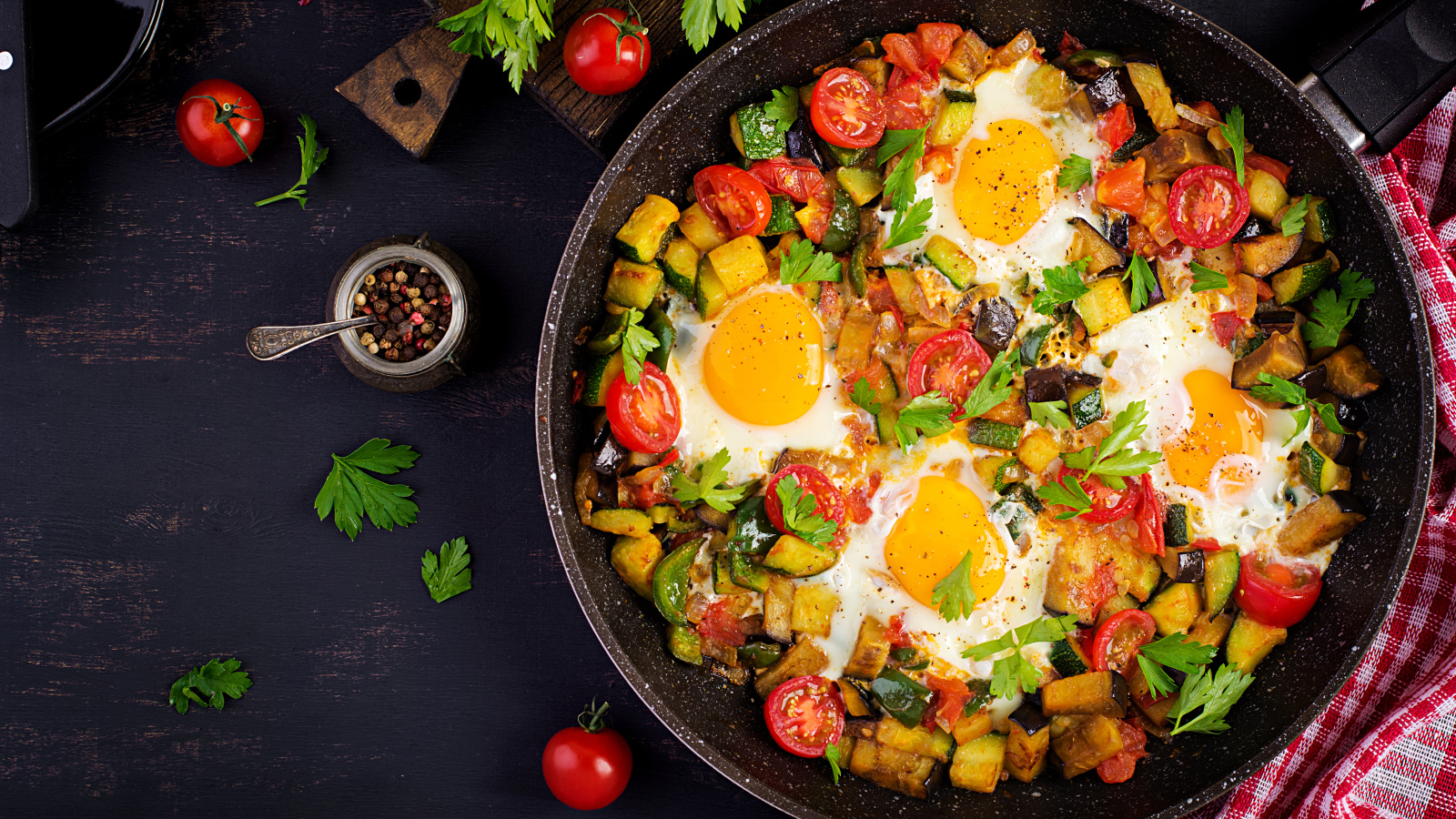 Яичница с овощами в сковороде на столе