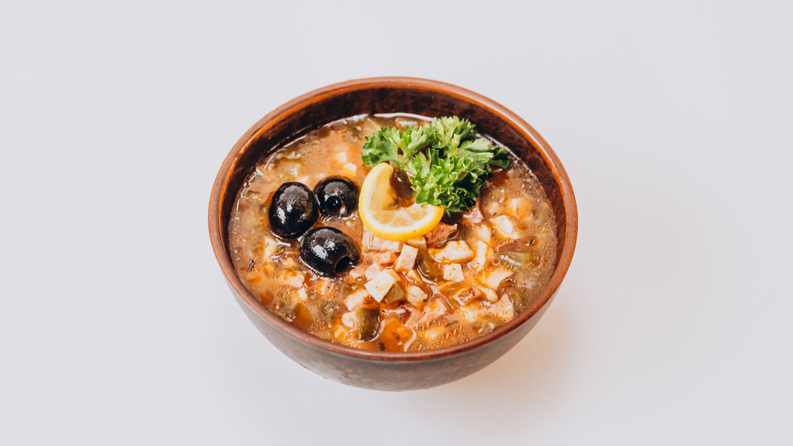 Солянка в тарелке на сером фоне