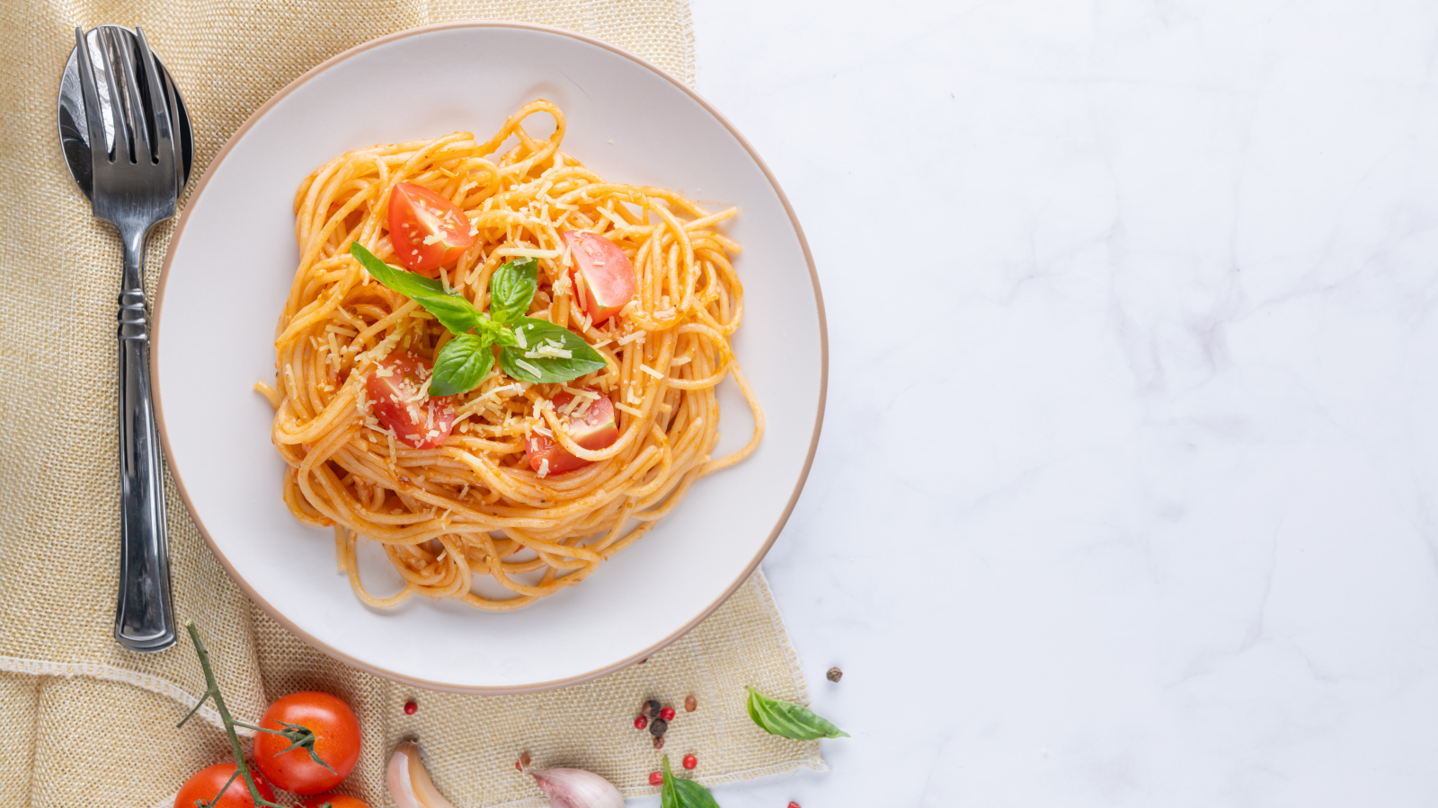 Спагетти с помидорами в тарелке на столе