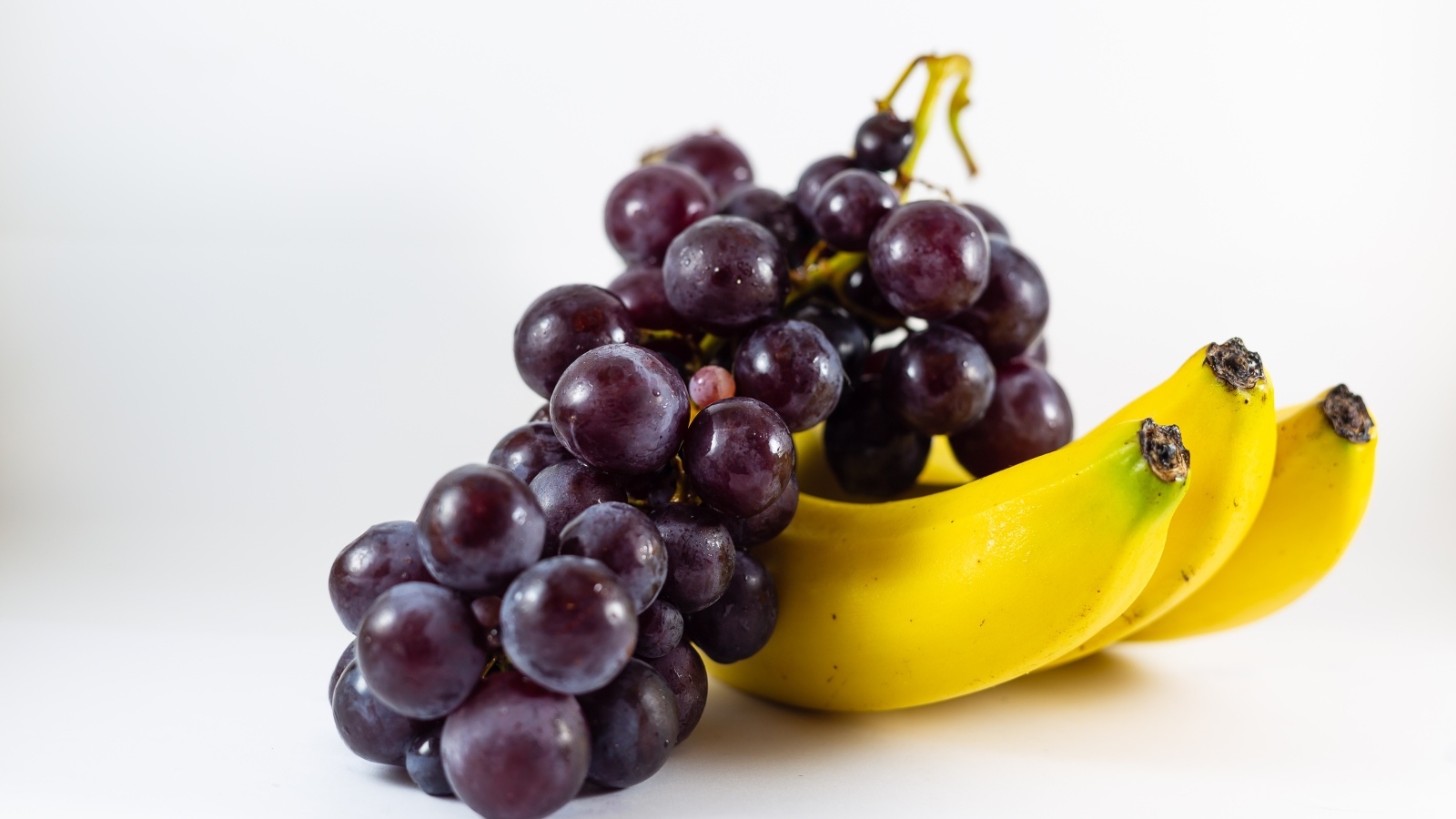 Гроздь винограда с бананами на столе