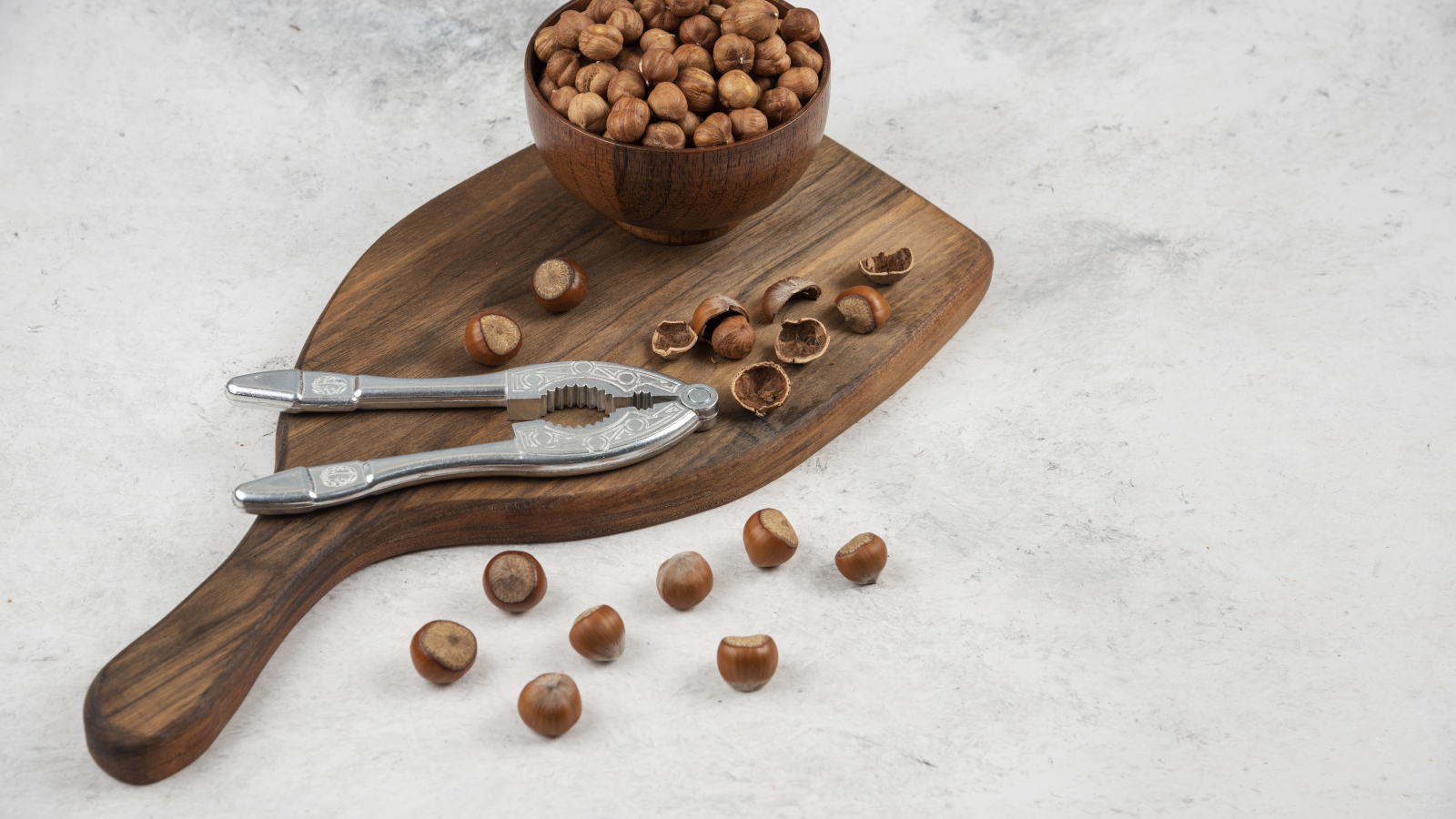 Лесные орехи на сером столе с разделочной доской