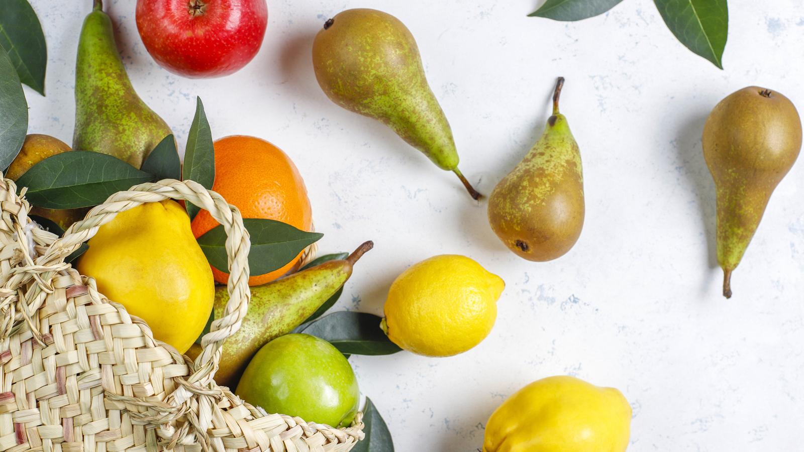 Груши, яблоки и апельсины с сумкой на столе