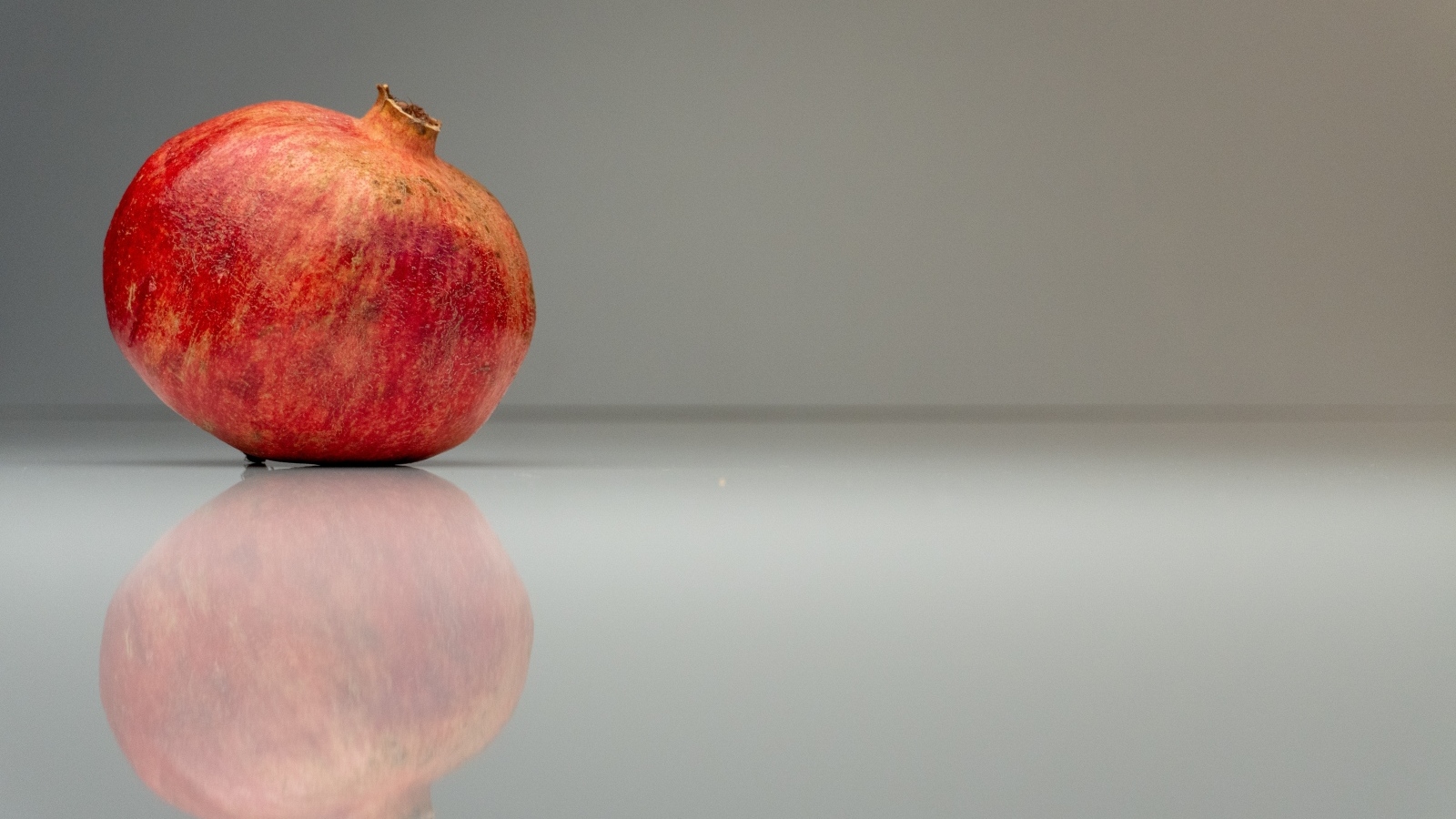 Красный гранат отражается в серой зеркальной поверхности