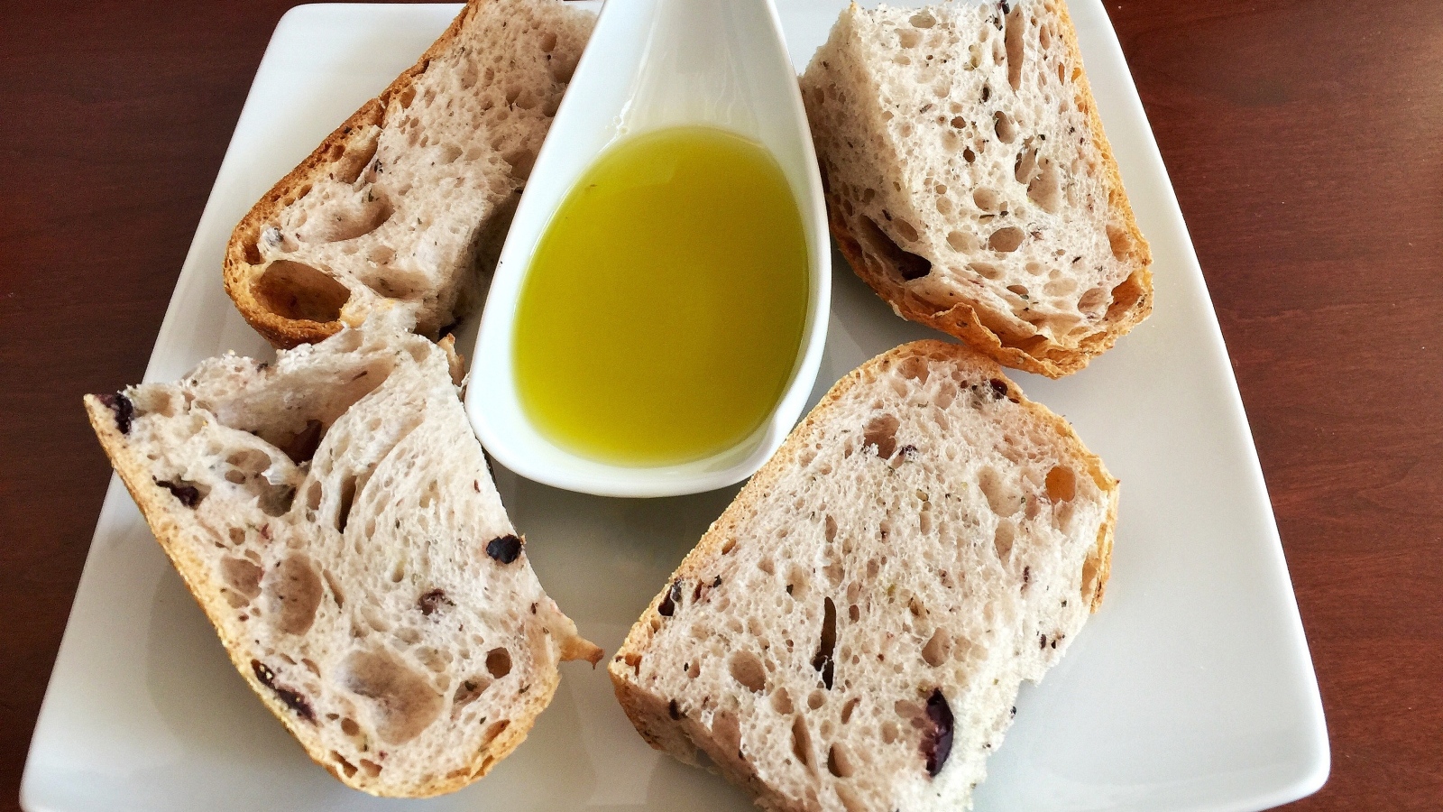 Свежий ароматный хлеб с оливковым  маслом на тарелке