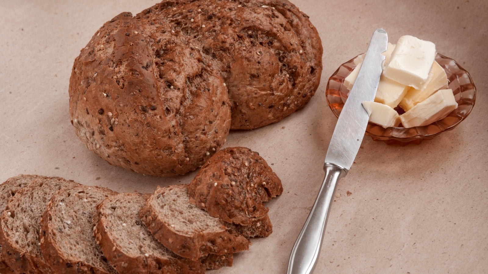 Ржаной хлеб со сливочным маслом и ножом на столе