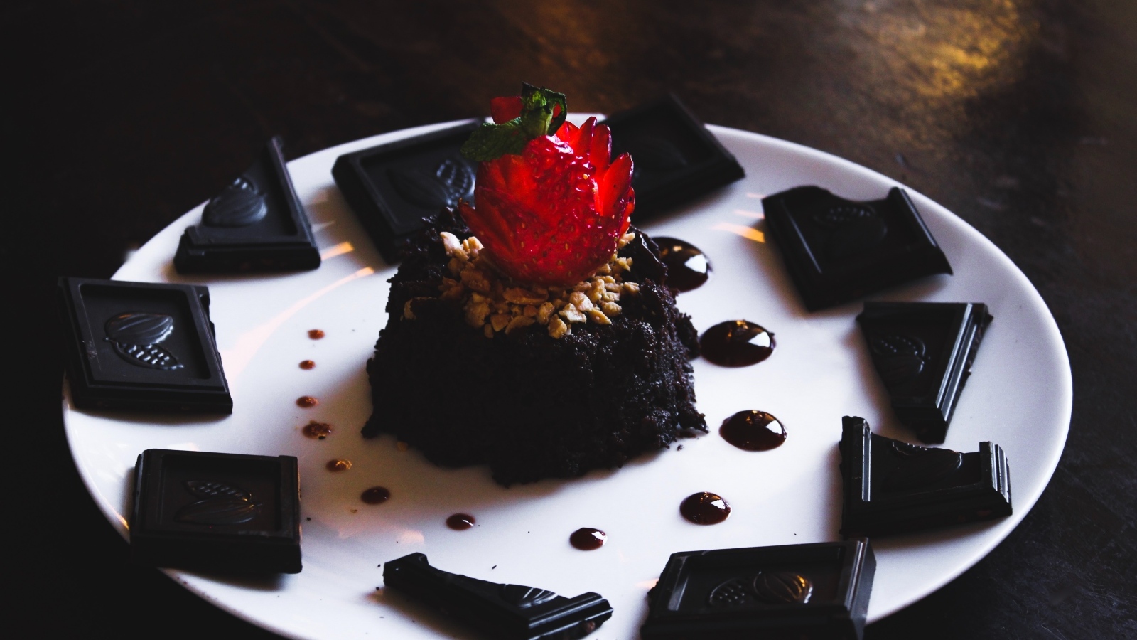 Десерт брауни на большой белой тарелке с шоколадом