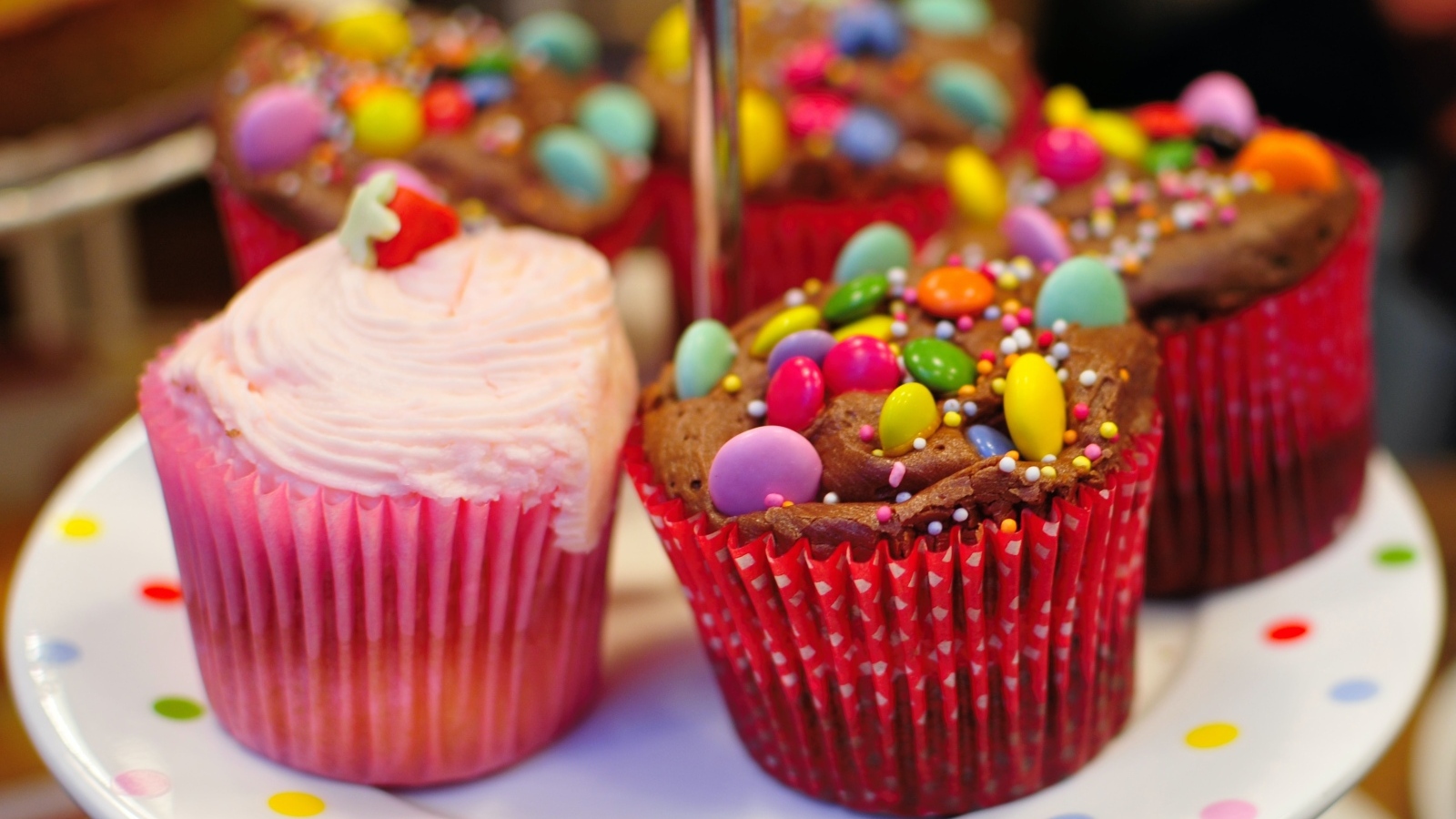 Кексы с розовым кремом и разноцветными конфетами