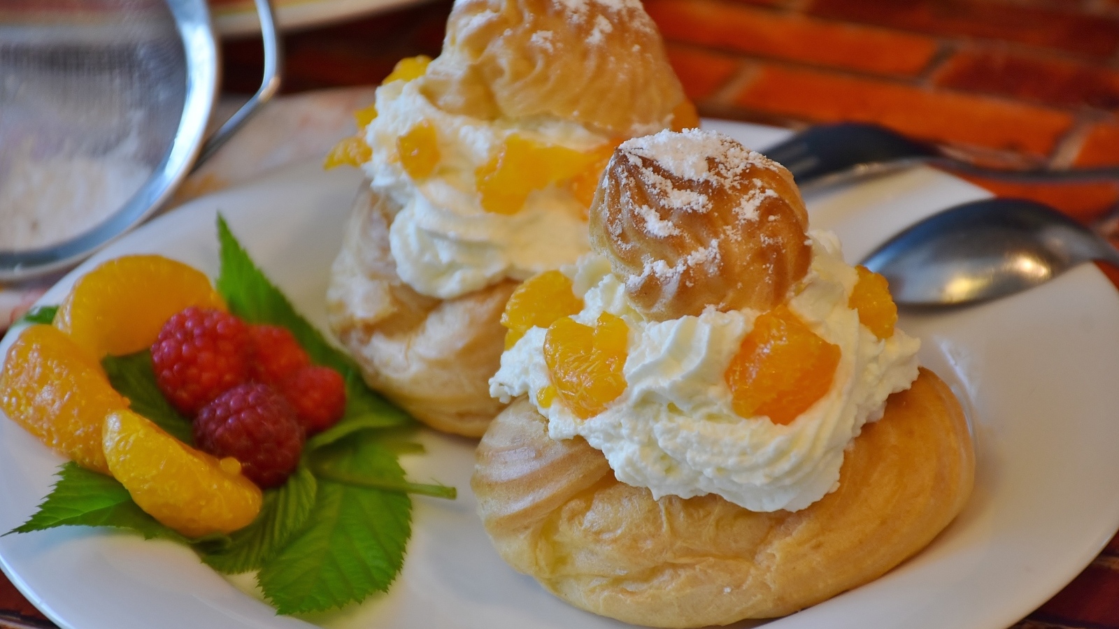 Заварное печенье со взбитыми сливками на тарелке с ягодами