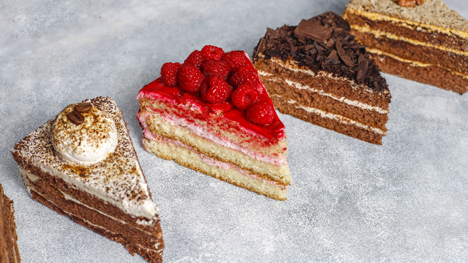 Четыре разных вкусных куска торта на столе