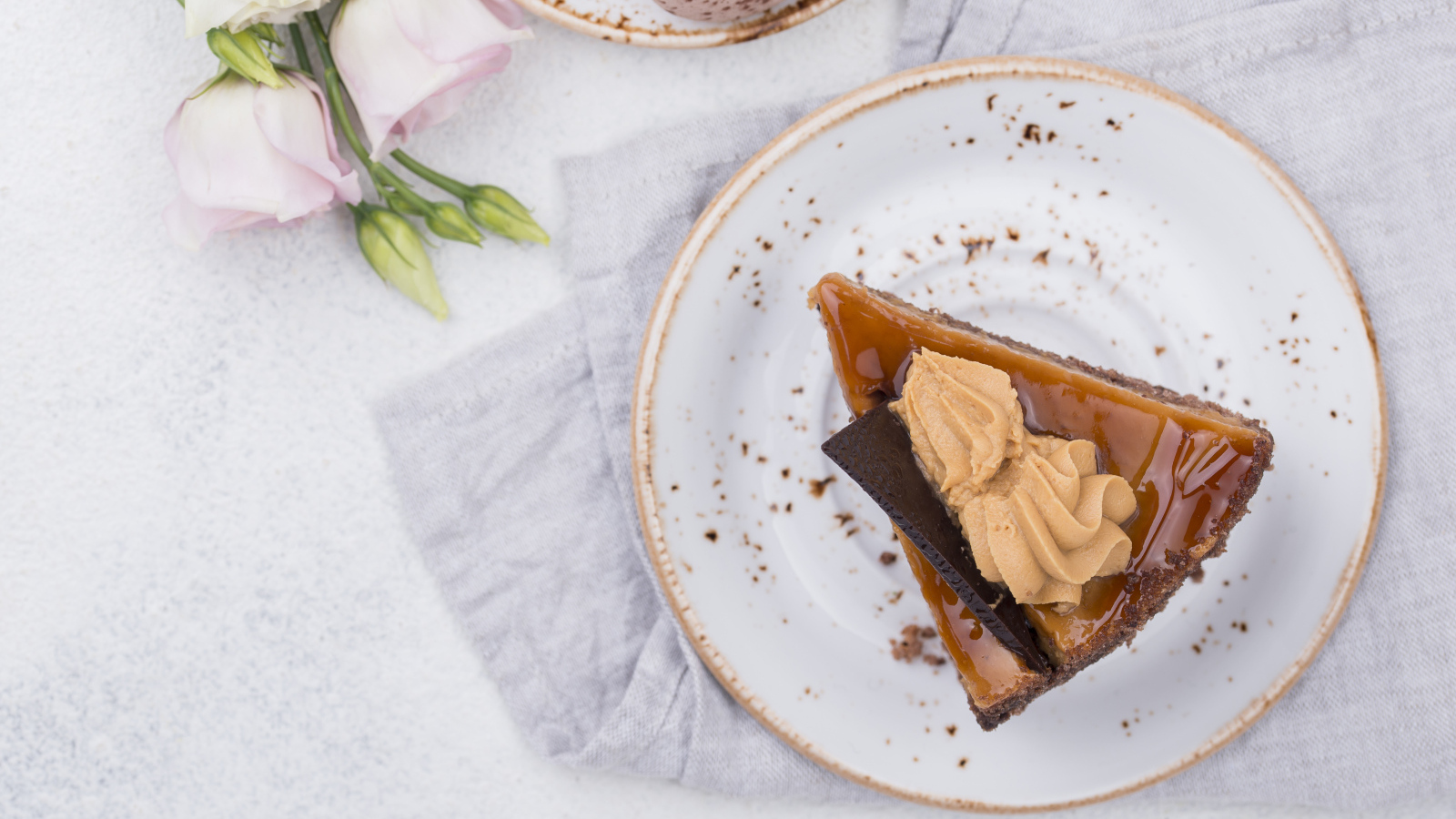 Кусок торта на тарелке на столе с цветами