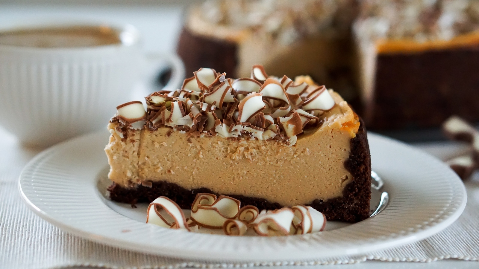 Кусок торта с шоколадной стружкой на белой тарелке