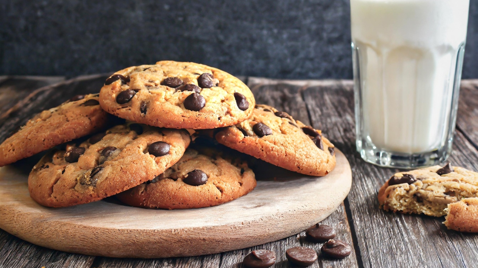 Круглое печенье с шоколадом на столе со стаканом молока