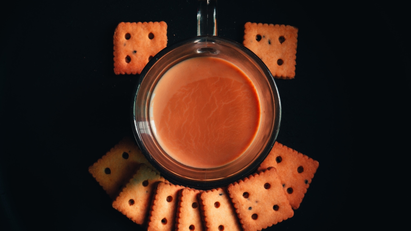 Чашка какао с печеньем на черном фоне