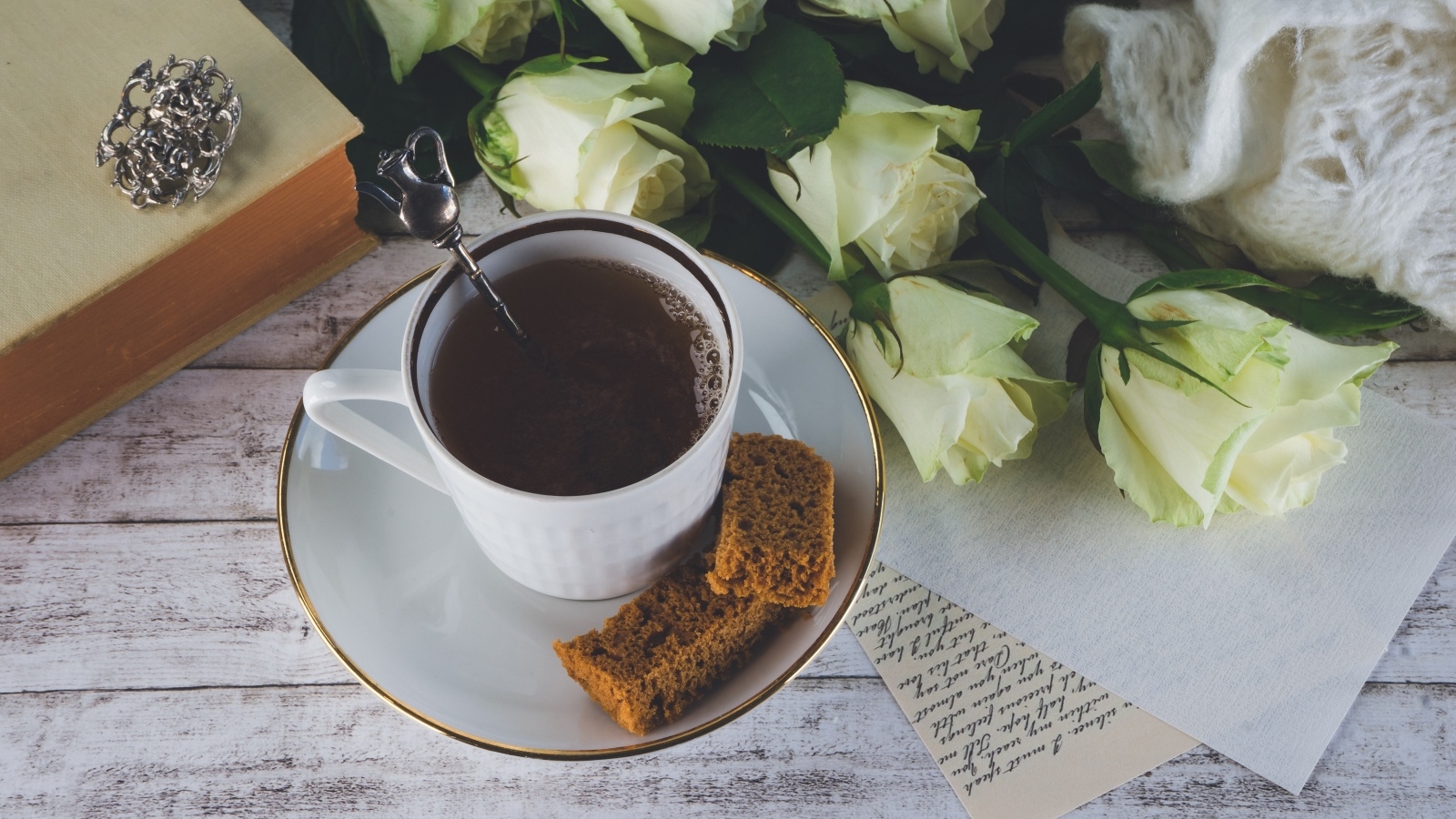 Чашка кофе на столе с букетом белых роз