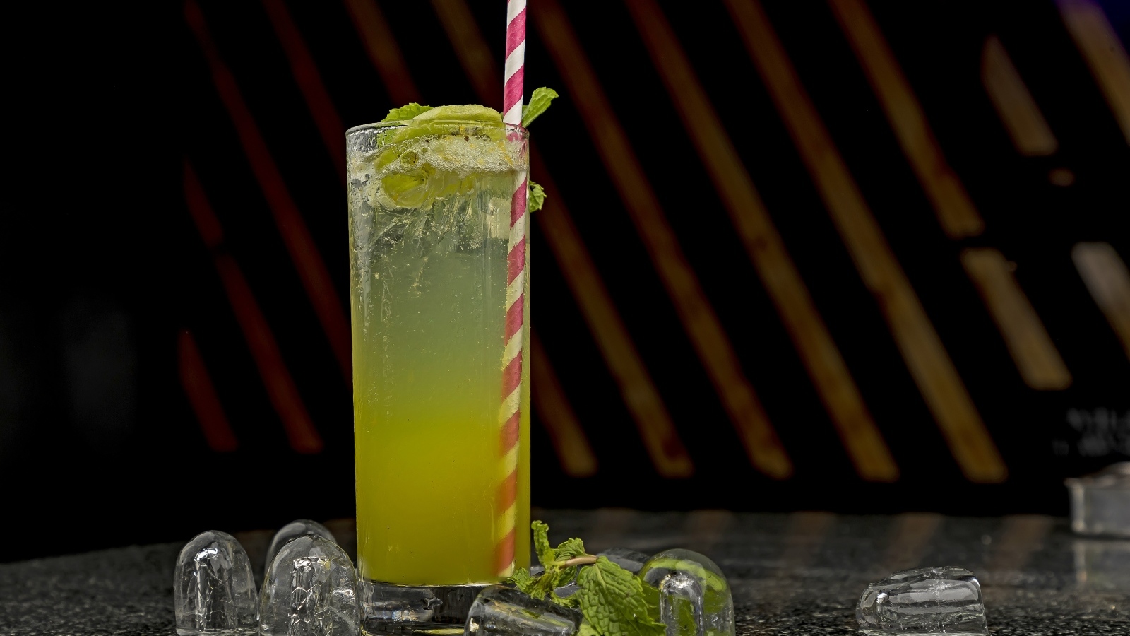 Зеленый коктейль мохито в высоком стакане со льдом