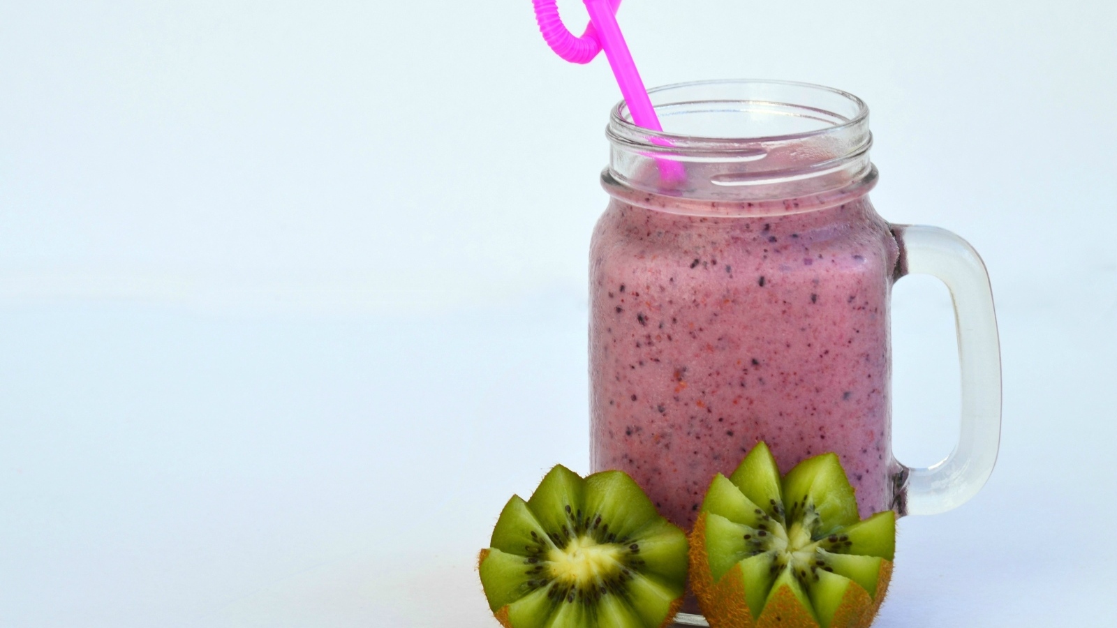 Розовый ягодный смузи на столе с киви