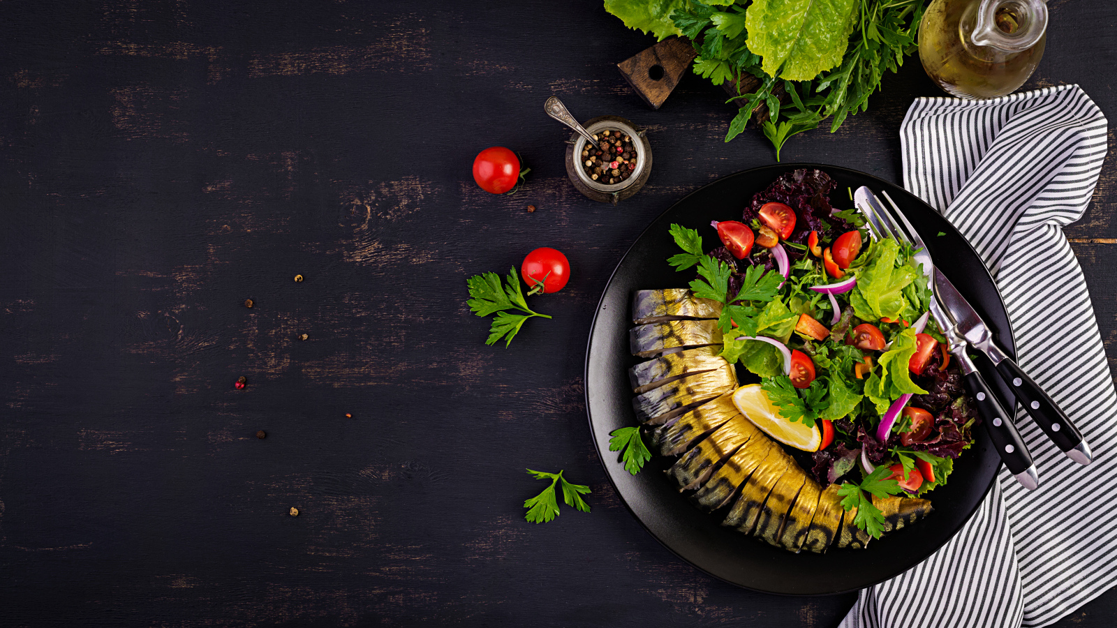 Скумбрия с салатом на тарелке на столе