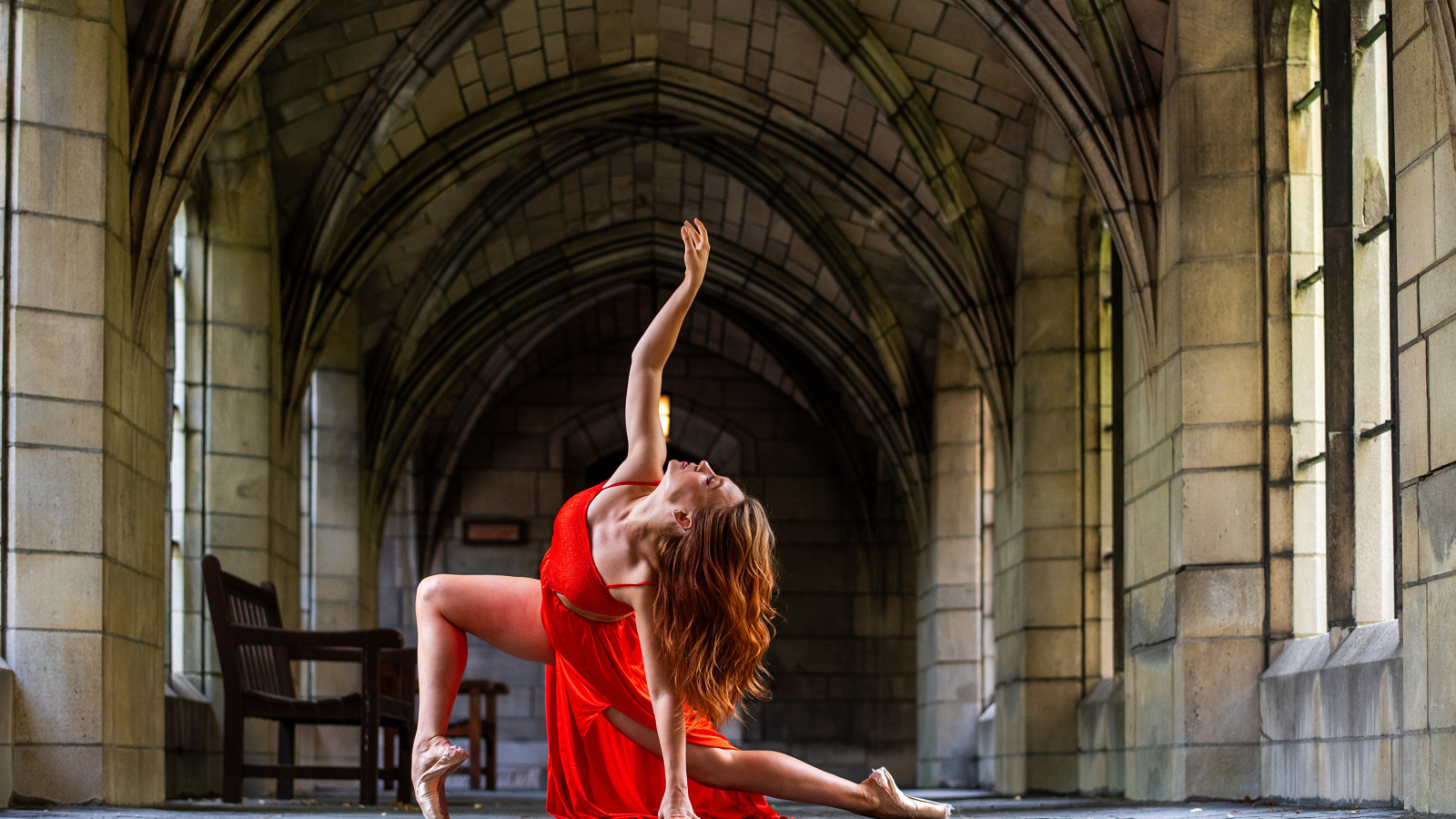 Девушка в красном наряде танцует в здании