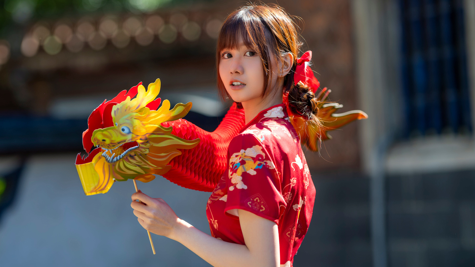 Азиатка в красном платье с бумажным драконом