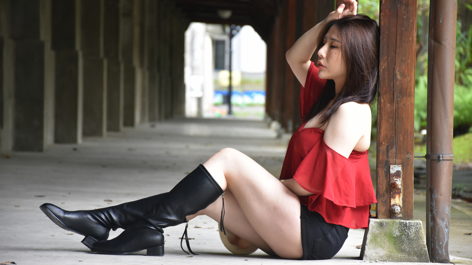 Азиатка с закрытыми глазами в черных сапогах
