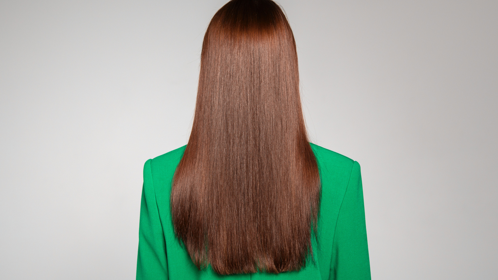 Красивые волосы девушки в зеленом пиджаке