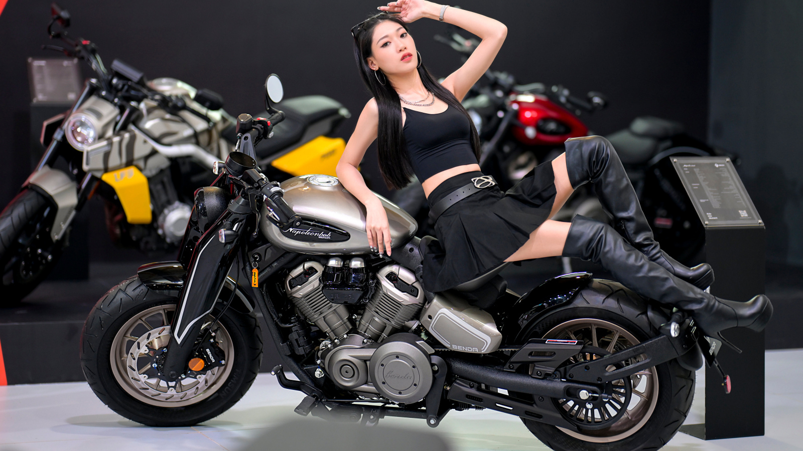 Брюнетка азиатка лежит на мотоцикле