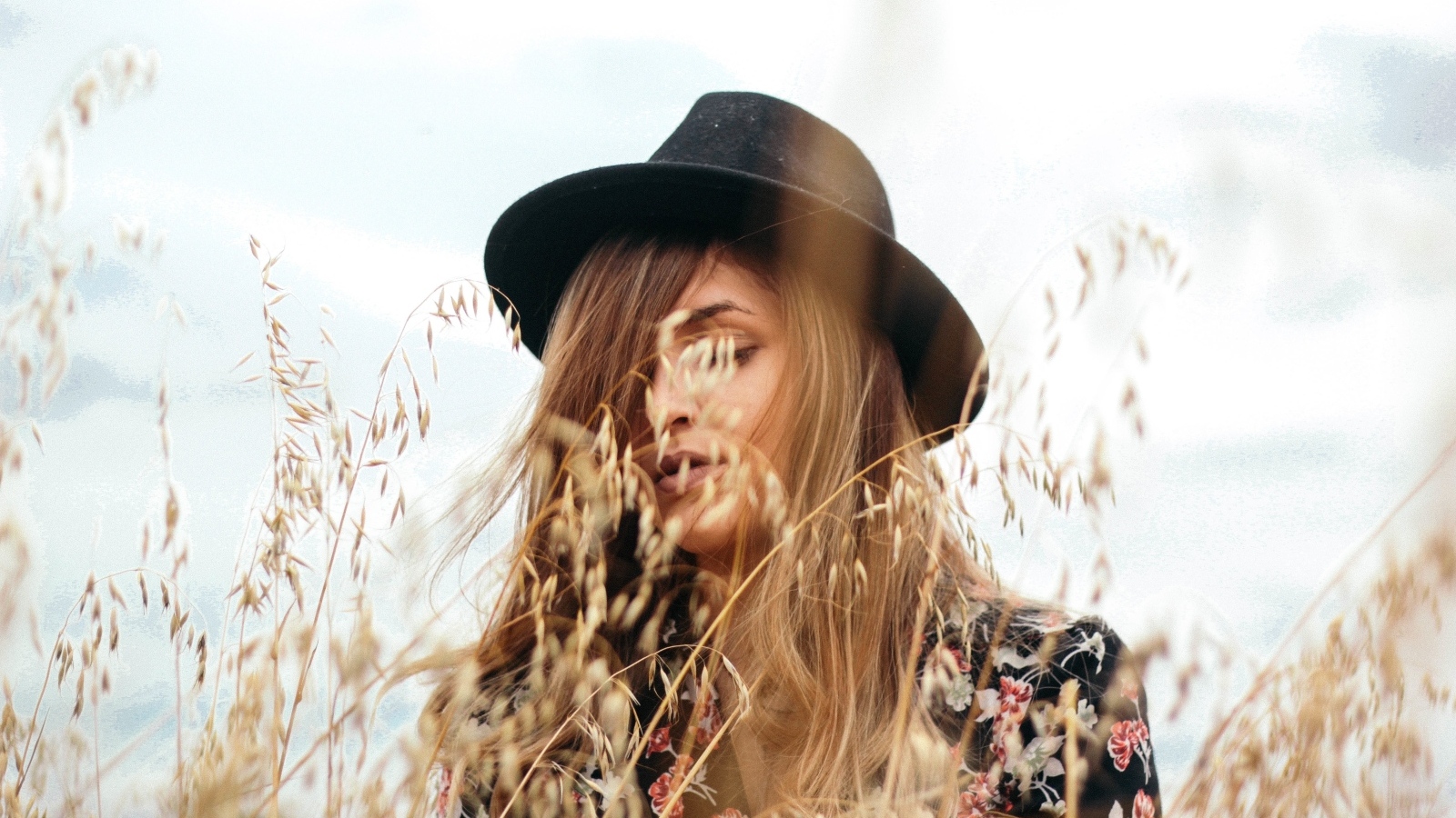 Девушка в черной шляпе в траве